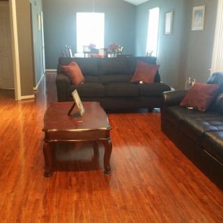 A cozy living room with wooden floors and comfortable sofas.