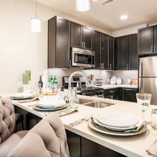 A modern kitchen and dining area with sleek, stainless steel appliances and contemporary furnishings.