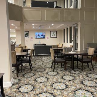 A cozy and modern dining area featuring tables, chairs, and a television in the background.