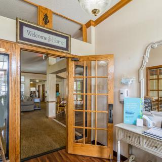 A welcoming entrance to a home with wooden doors and decorative furnishings.