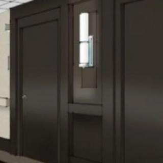 A dark brown paneled door with a narrow window in an interior setting.