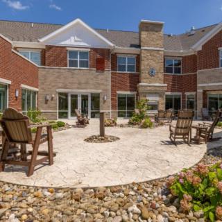 A modern residential building with a well-maintained outdoor patio area and seating.