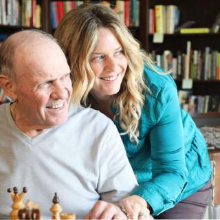 A happy moment shared while playing chess in a cozy library setting.