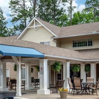 A cozy residential patio area with outdoor furniture, surrounded by trees.