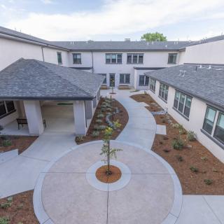 A modern building with a landscaped courtyard and circular pathway.