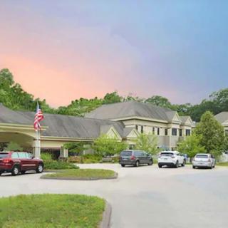 A scenic view of a building with a parking lot at sunset.