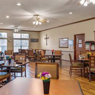 A well-lit dining area with neatly arranged tables and chairs, featuring tasteful decor.