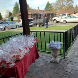 A patio setting with a table covered in wrapped gifts, overlooking a parking area with several cars.