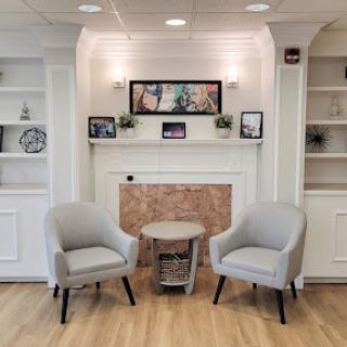A cozy seating area featuring two modern chairs and decorative shelves, creating a warm and inviting space.