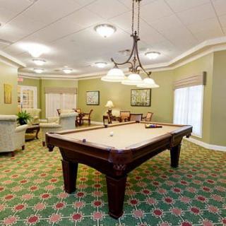 A spacious and well-lit game room featuring a pool table.