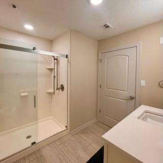 A modern bathroom with a glass shower enclosure and sleek sink.