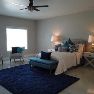 A stylish and cozy modern bedroom featuring blue accents.
