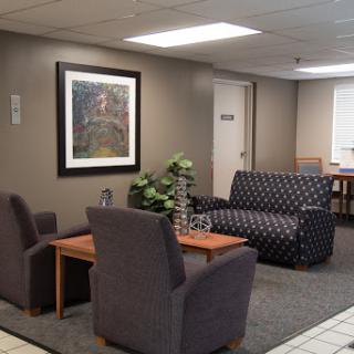A cozy waiting area featuring comfortable seating and decorative artwork.