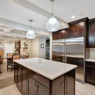 A modern kitchen featuring a central island with pendant lighting and stainless steel appliances.