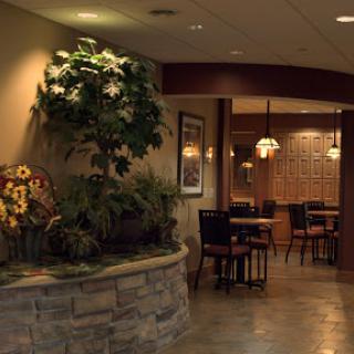 A warm and inviting dining area featuring decorative plants and ambient lighting.