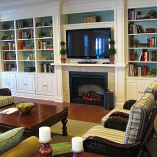 A cozy living room featuring a fireplace, built-in shelves, and comfortable seating arrangements.