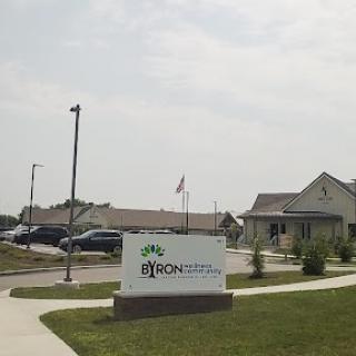 A view of a community center with a prominent sign and an American flag in the background.