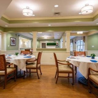 A well-lit dining room with neatly arranged tables and chairs, featuring a cozy and inviting interior.