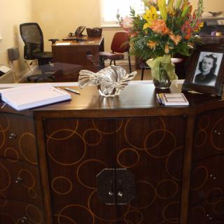 An office desk with flowers, a photograph, and various office items.