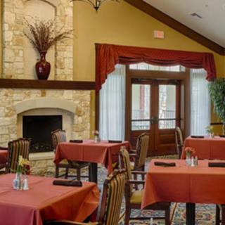 A cozy dining area with neatly arranged tables and a warm fireplace.