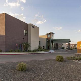 A modern building with a desert landscape under a clear sky.