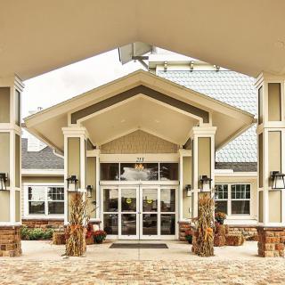 A modern building entrance with a peaked roof and glass doors.