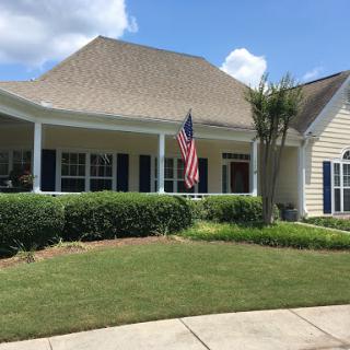 A charming suburban home with well-maintained landscaping and an American flag proudly displayed.