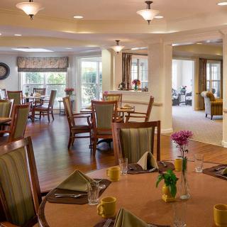 An elegant dining room with neatly arranged tables and chairs, featuring a warm and inviting interior design.