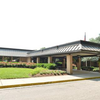 A view of a modern commercial building with a landscaped entrance.