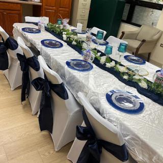 Beautifully arranged dining table set for a formal event with navy blue and silver accents.