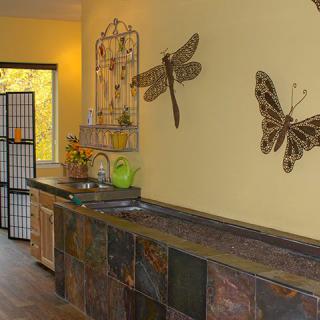 A cozy interior featuring butterfly and dragonfly wall art against warm yellow walls, complemented by a rustic kitchen counter.