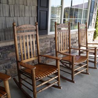Wooden rocking chairs lined up on a porch.