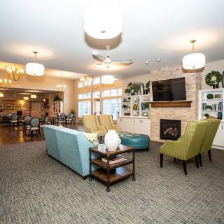 A modern and cozy living room with comfortable seating, a fireplace, and stylish lighting fixtures.