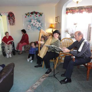 A cozy family gathering with musical entertainment in a living room setting.