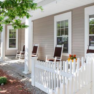A cozy front porch with rocking chairs and a white picket fence.