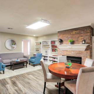 A modern living room with a cozy fireplace, comfortable seating, and stylish decor.