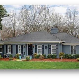 A cozy blue single-story house with a well-maintained front yard.