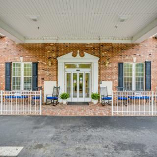 A welcoming entrance to a brick building with benches and a covered walkway.