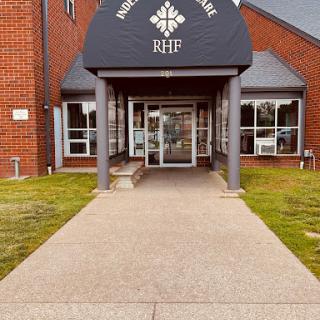 Entrance of a modern building with a well-maintained pathway and landscaping.