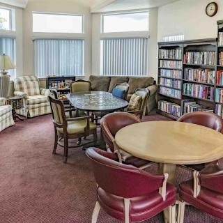 A cozy living space with comfortable seating, bookshelves, and tables for gathering or reading.