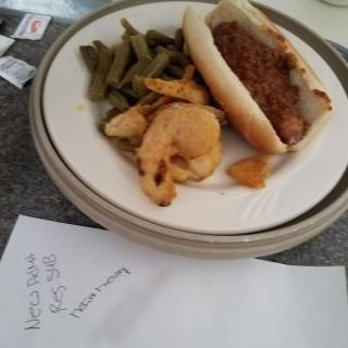 A plate with a hot dog, green beans, and chips.