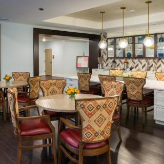A modern dining area with patterned chairs and a bar counter.