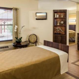 A cozy and well-decorated bedroom with a focus on warmth and comfort, featuring an elegant plant and stylish furnishings.