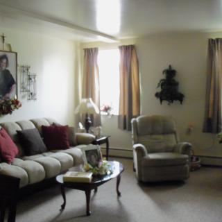 A cozy living room with a sofa, armchair, and coffee table.