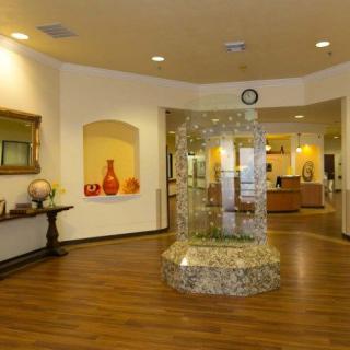 A warmly decorated lobby area with a central fountain and art pieces on the walls.