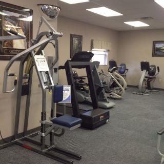 A small gym with various exercise equipment, including treadmills and strength machines.