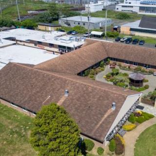 Aerial view of a building with a courtyard and surrounding greenery.