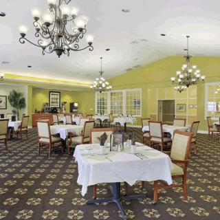 A spacious dining area with elegant chandeliers and neatly arranged tables.