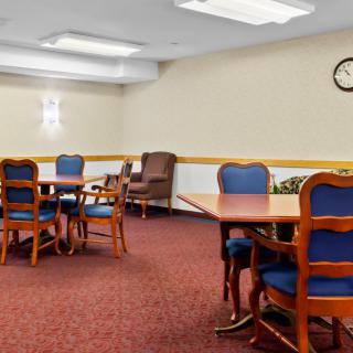 A spacious meeting room with multiple tables and chairs.