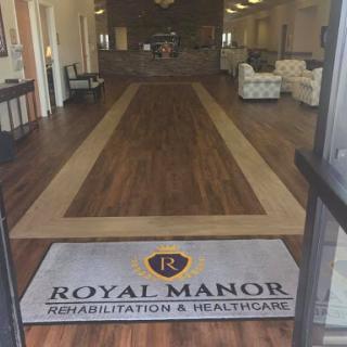 Entrance to Royal Manor Rehabilitation & Healthcare, featuring a welcoming lobby with wood flooring.